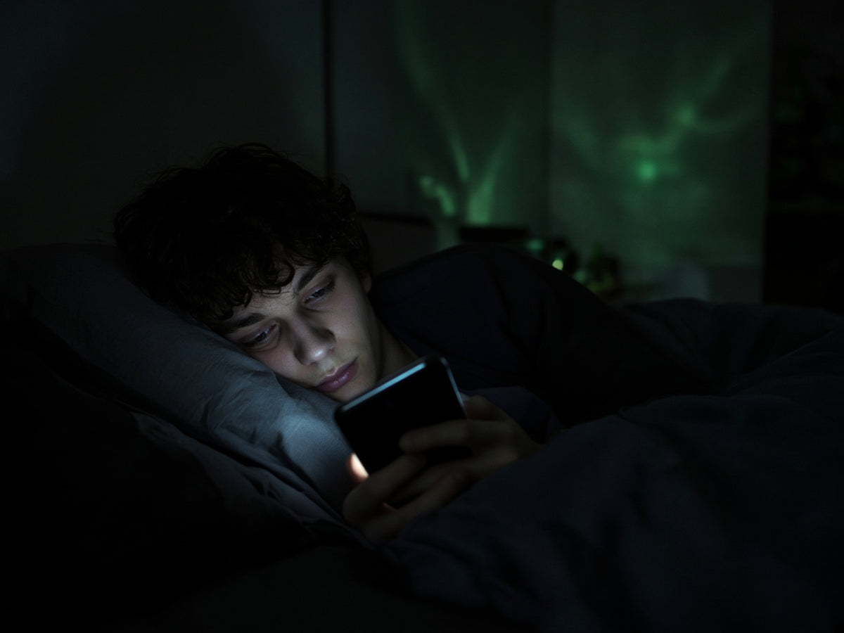 Persona en la cama de madrugada iluminada solo por la pantalla del móvil